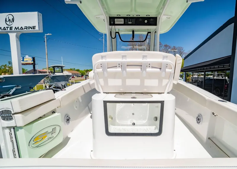 Slide: The Image of 2025 Sea Hunt Gamefish 25 boat interior with seating and storage, displayed at a marine dealership. - 11