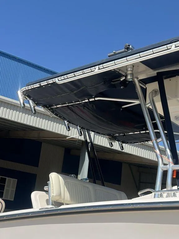 Slide: The Image of 2003 Grady-White 306 Bimini boat with T-top and seating, docked under clear blue sky. - 16