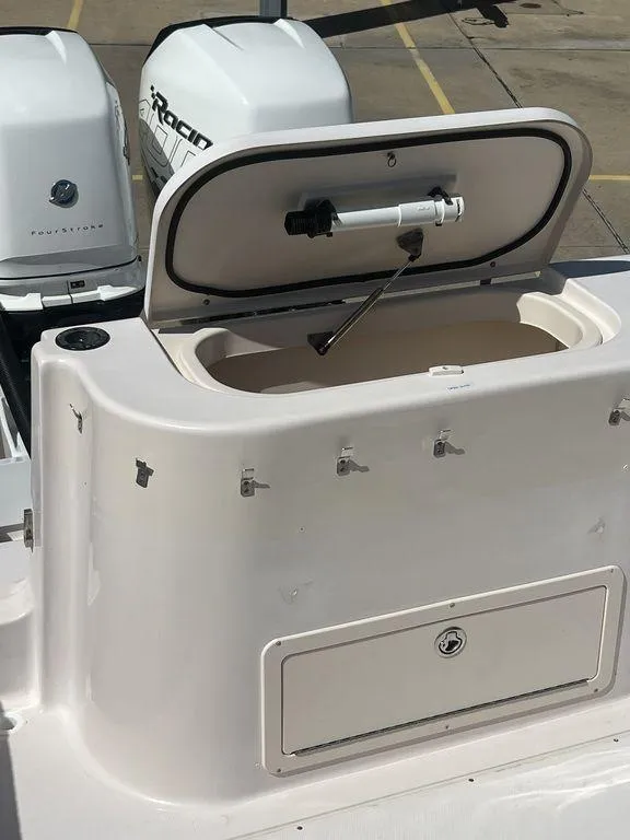 Slide: The Image of 2003 Grady-White 306 Bimini boat with open storage compartment and visible outboard engines. - 19