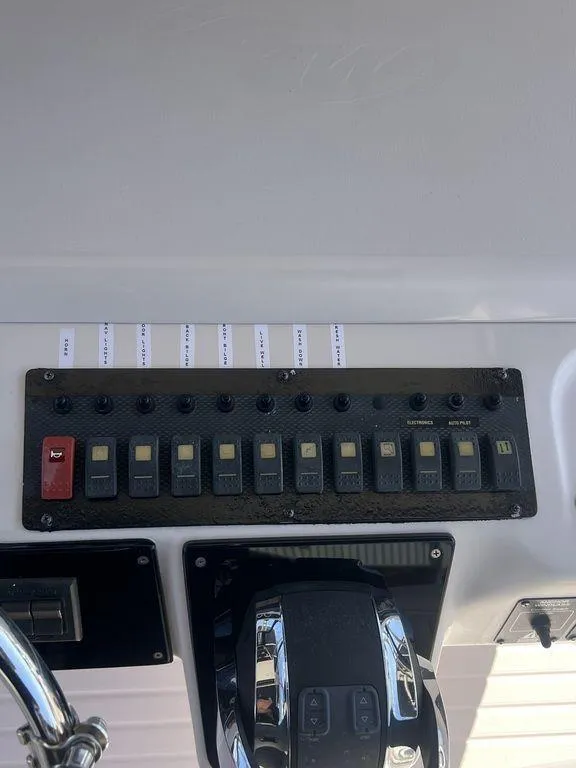 Slide: The Image of Control panel of a 2003 Grady-White 306 Bimini boat with switches and throttle. - 24