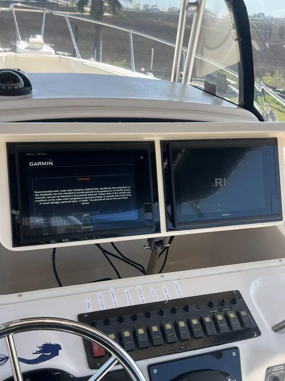 Slide: The Image of 2003 Grady-White 306 Bimini boat dashboard with Garmin navigation screens. - 29