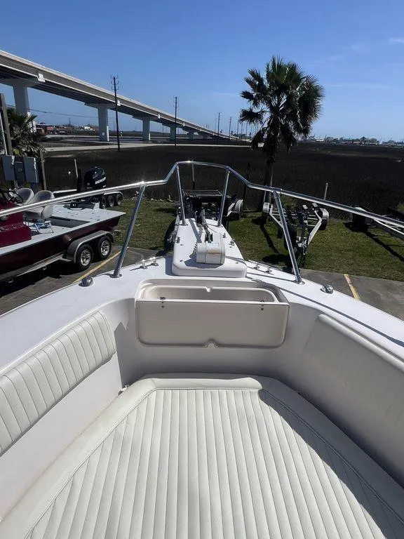 Slide: The Image of 2003 Grady-White 306 Bimini boat with white seating, docked near a highway and palm tree. - 39