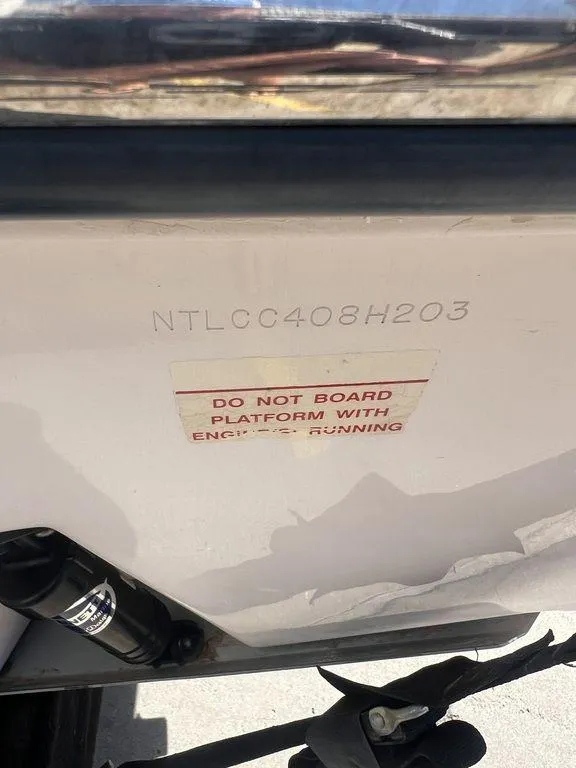 Slide: The Image of 2003 Grady-White 306 Bimini boat with safety warning label and hull identification number. - 48