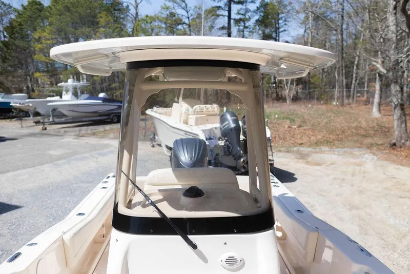 Slide: The Image of 2023 Grady-White Fisherman 236 boat, front view, parked outdoors with trees in background. - 10