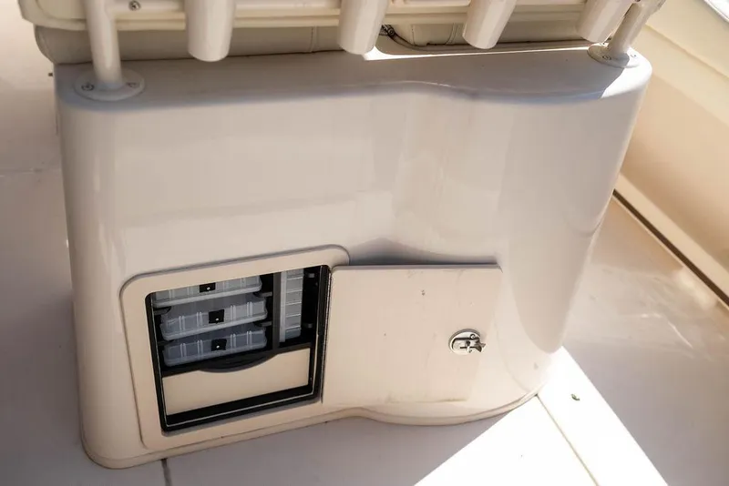 Slide: The Image of 2023 Grady-White Fisherman 236 boat storage compartment with open door and tackle boxes. - 14