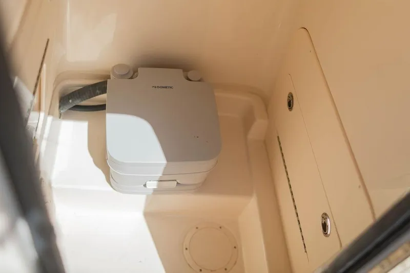 Slide: The Image of 2023 Grady-White Fisherman 236 boat interior with portable toilet in storage compartment. - 16