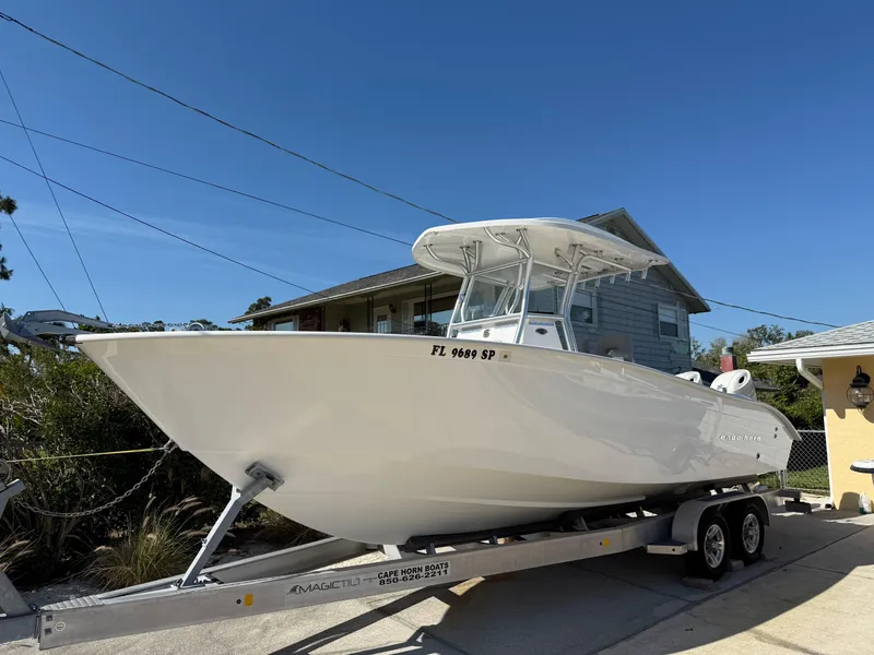 The Image of 2020 Cape Horn 27 XS boat on trailer, parked in driveway under clear blue sky. - 0