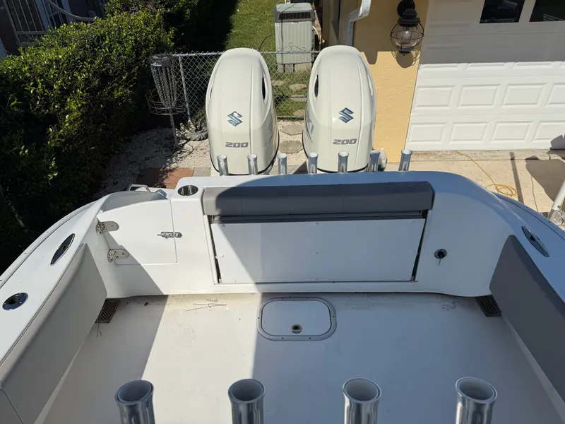 Slide: The Image of 2020 Cape Horn 27 XS boat with twin Suzuki 200 engines, docked near a garage. - 14