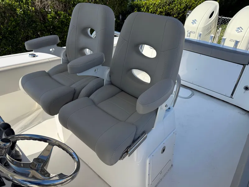Slide: The Image of 2020 Cape Horn 27 XS boat with dual gray captain's chairs and steering wheel. - 28