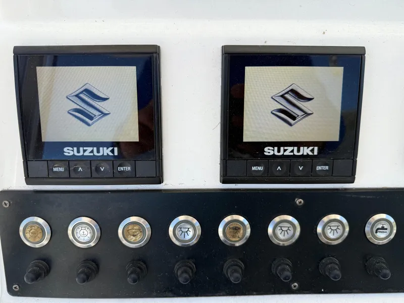 Slide: The Image of 2020 Cape Horn 27 XS boat dashboard with dual Suzuki displays and control switches. - 43
