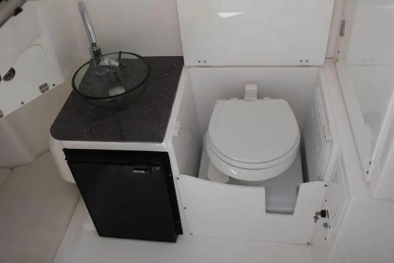 Slide: The Image of 2015 Everglades 355 Center Console boat bathroom with sink, toilet, and storage. - 13