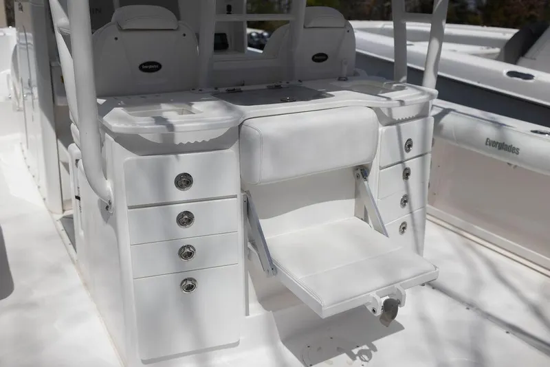 Slide: The Image of 2015 Everglades 355 Center Console boat interior with white seating and storage compartments. - 28