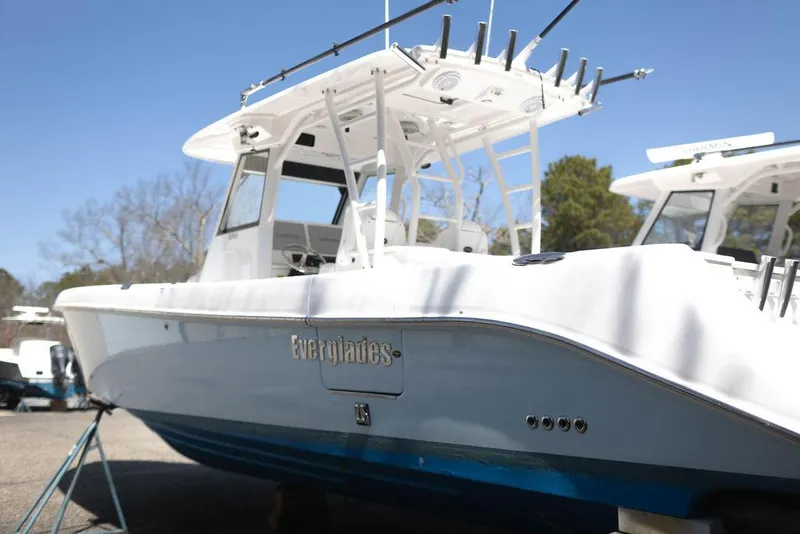 Slide: The Image of 2015 Everglades 355 Center Console boat with white hull and blue bottom, docked outdoors. - 3