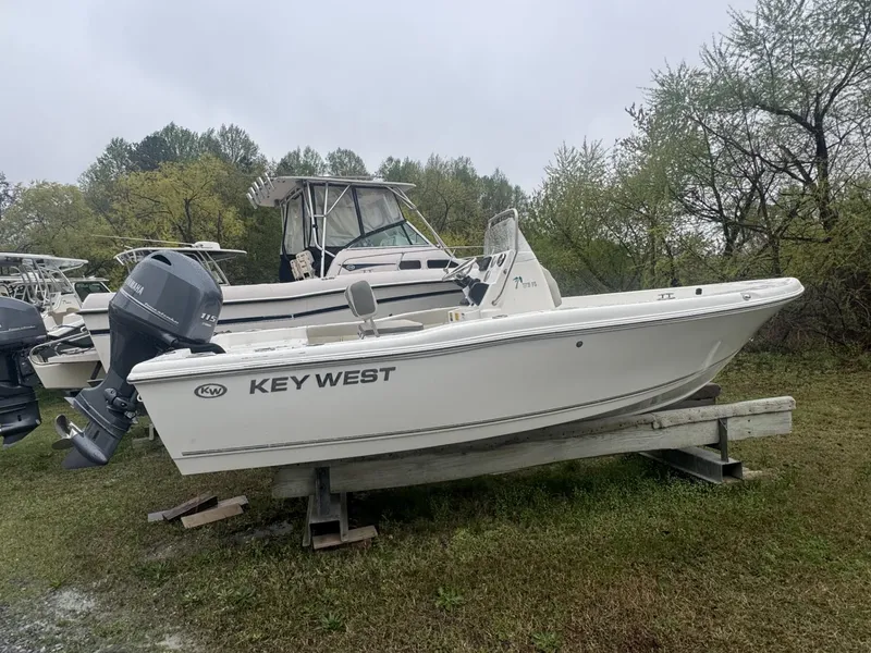 The Image of 2025 Key West 179 FS boat on display outdoors, surrounded by trees and other boats. - 0