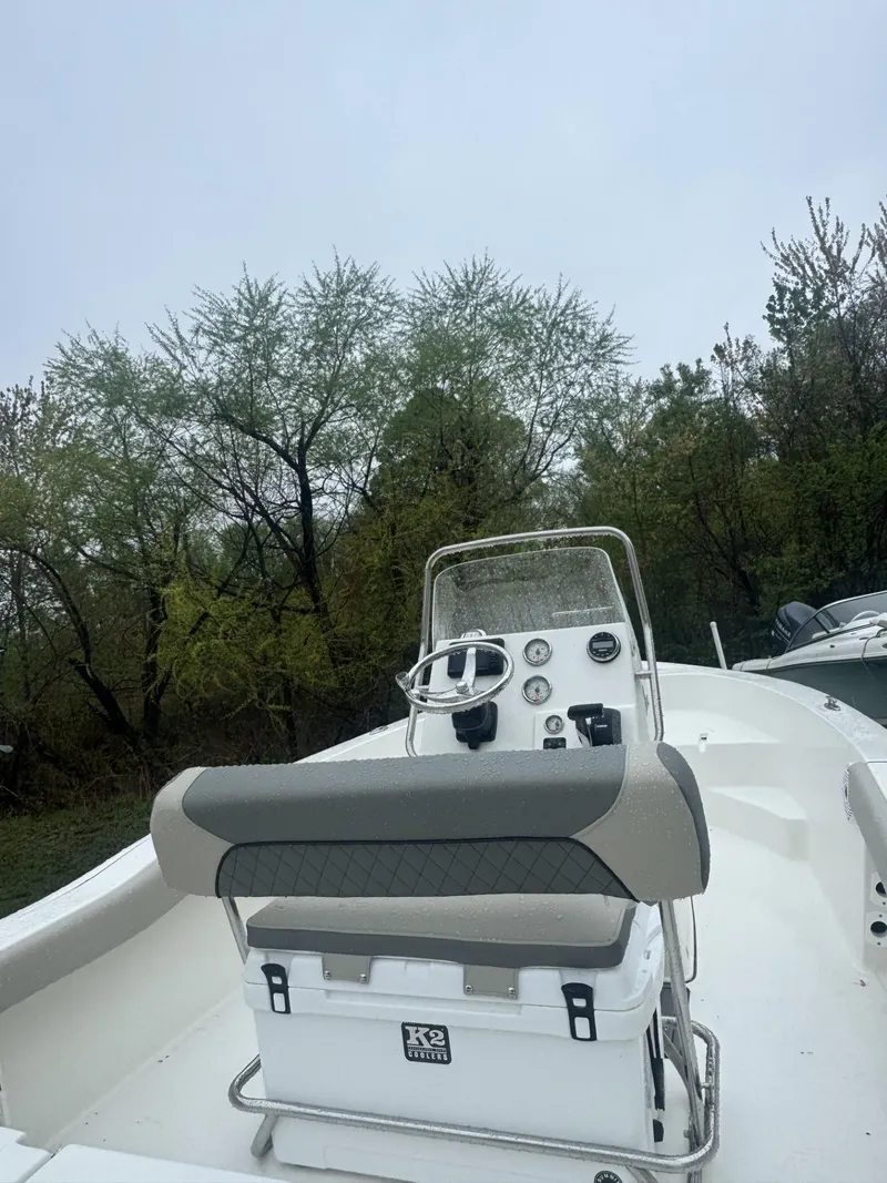 Slide: The Image of 2025 Key West 179 FS boat with console and seating, surrounded by trees. - 4