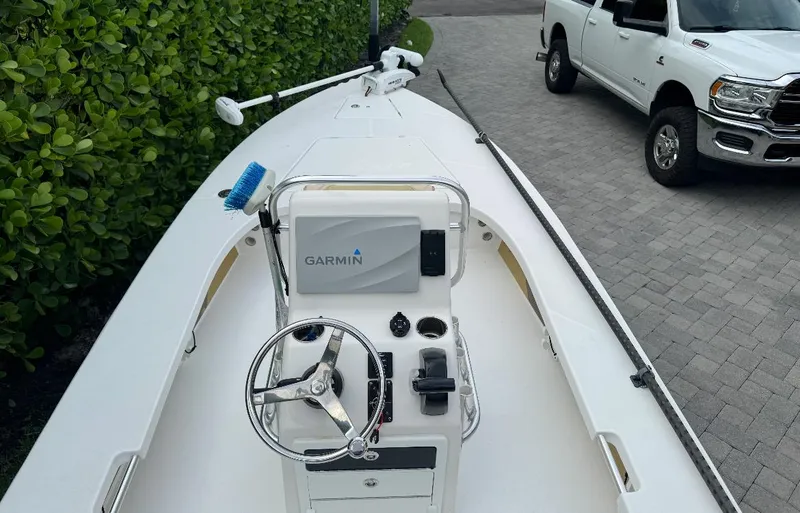 Slide: The Image of 2022 Blacktip Boatworks 18 Flats boat with Garmin system, parked near a white truck. - 6