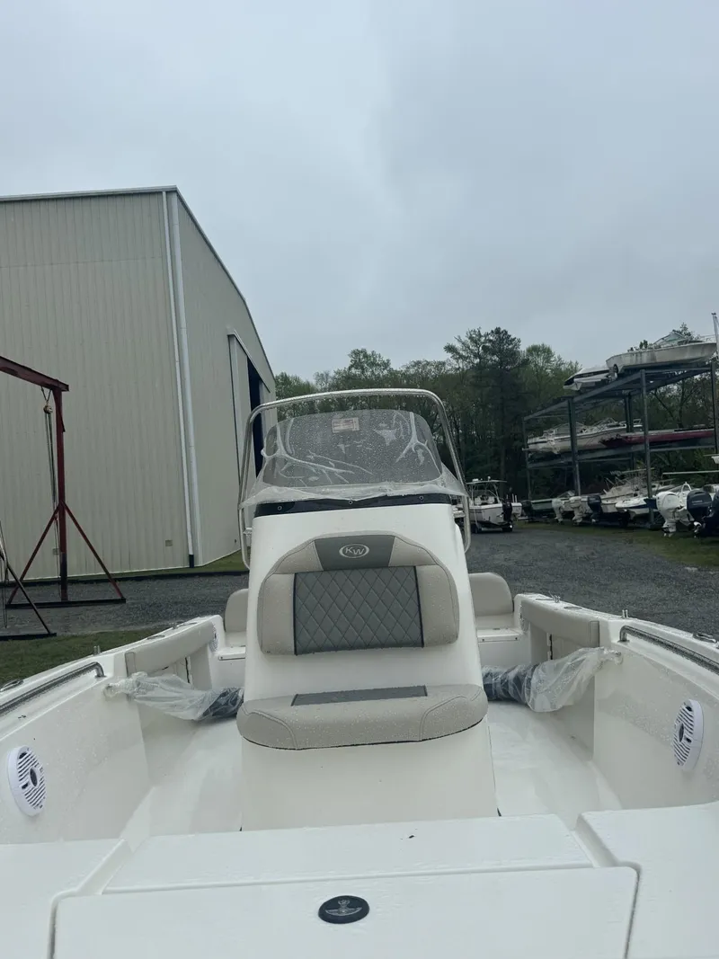 Slide: The Image of 2025 Key West 189 FS boat on a stand, side view, near a warehouse. - 1