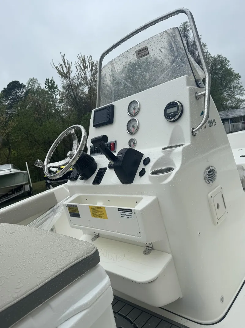 Slide: The Image of 2025 Key West 189 FS boat with seating, parked outdoors near a warehouse. - 2