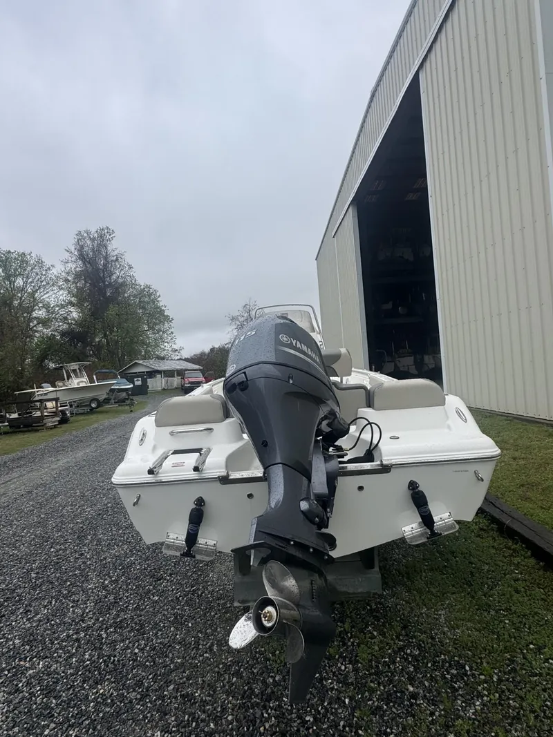 Slide: The Image of 2025 Key West 189 FS boat with console and seating, docked near a storage facility. - 4