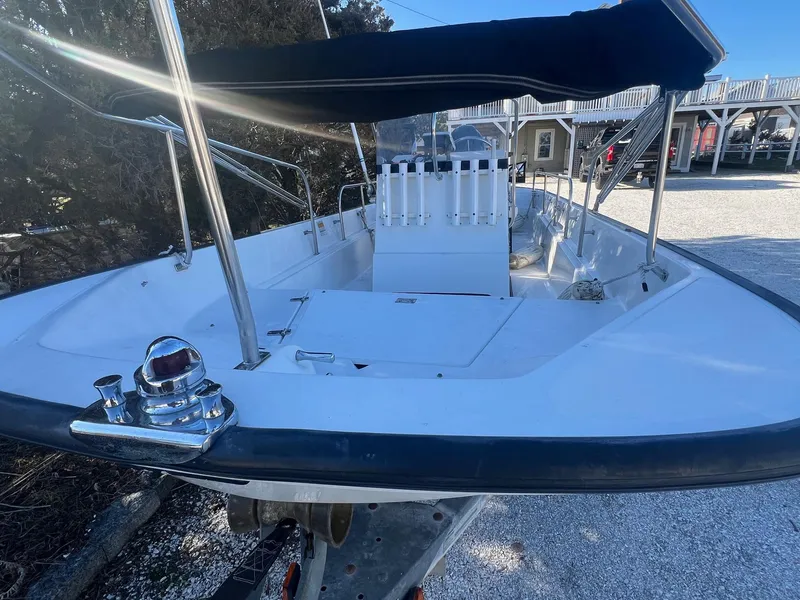 Slide: The Image of 2000 Boston Whaler 17 Montauk boat with canopy, docked outdoors. - 2