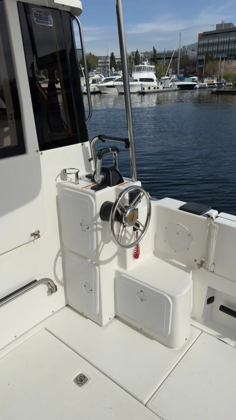 Slide: The Image of 2017 Cutwater C-302 Coupe boat helm with steering wheel, docked at marina. - 12