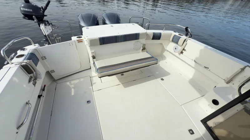 Slide: The Image of 2017 Cutwater C-302 Coupe boat deck with seating, featuring Yamaha engines, on calm water. - 14