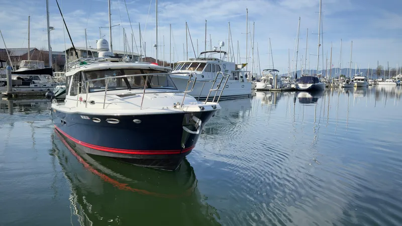 Slide: The Image of 2017 Cutwater C-302 Coupe boat docked in a marina with sailboats. - 19