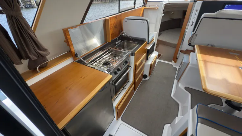 Slide: The Image of 2017 Cutwater C-302 Coupe interior with kitchen, dining area, and modern amenities. - 2