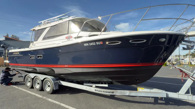 Slide: The Image of 2017 Cutwater C-302 Coupe boat on trailer, parked outdoors under clear sky. - 24