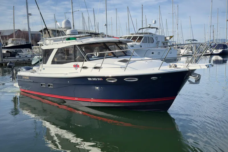 Slide: The Image of 2017 Cutwater C-302 Coupe boat docked in a marina, surrounded by other vessels. - 28