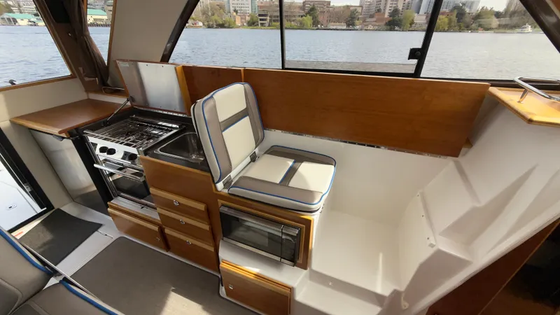 Slide: The Image of 2017 Cutwater C-302 Coupe interior with kitchen, seating, and scenic water view. - 5
