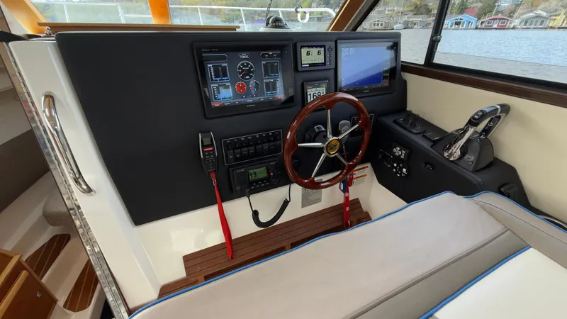 Slide: The Image of 2017 Cutwater C-302 Coupe helm with navigation screens and wooden steering wheel. - 6