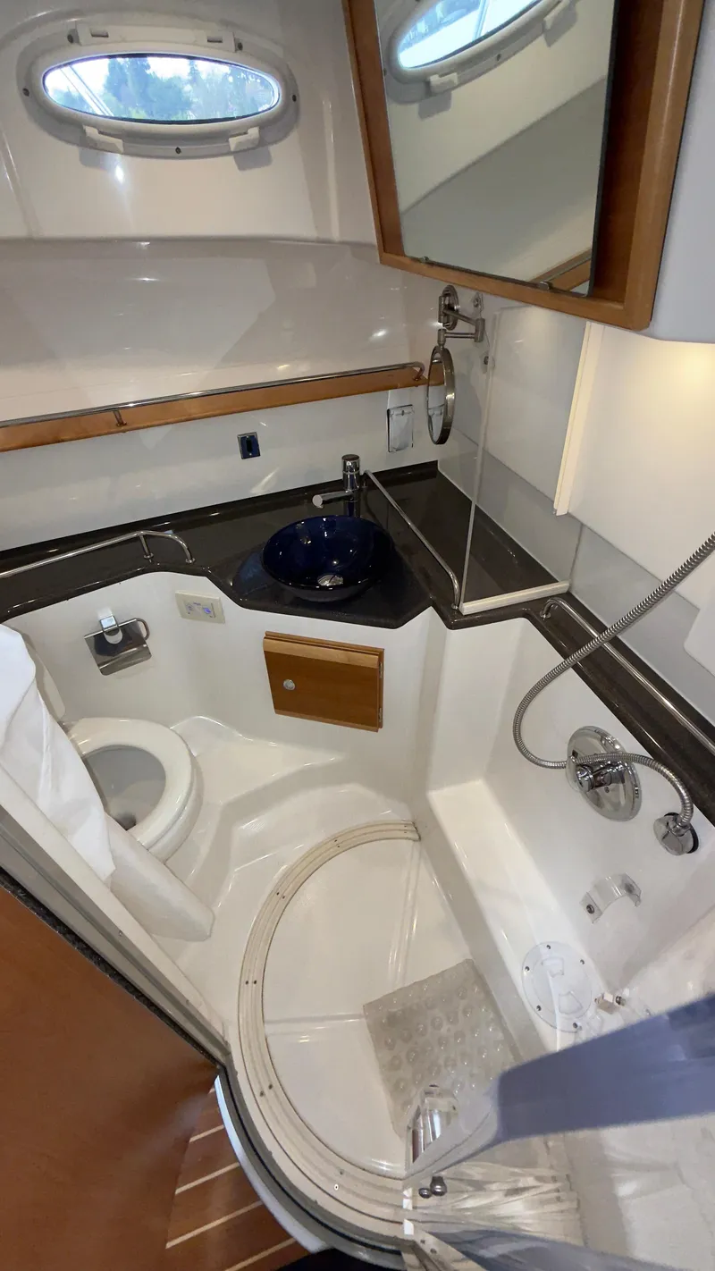 Slide: The Image of 2017 Cutwater C-302 Coupe bathroom with shower, sink, and toilet in compact marine design. - 9