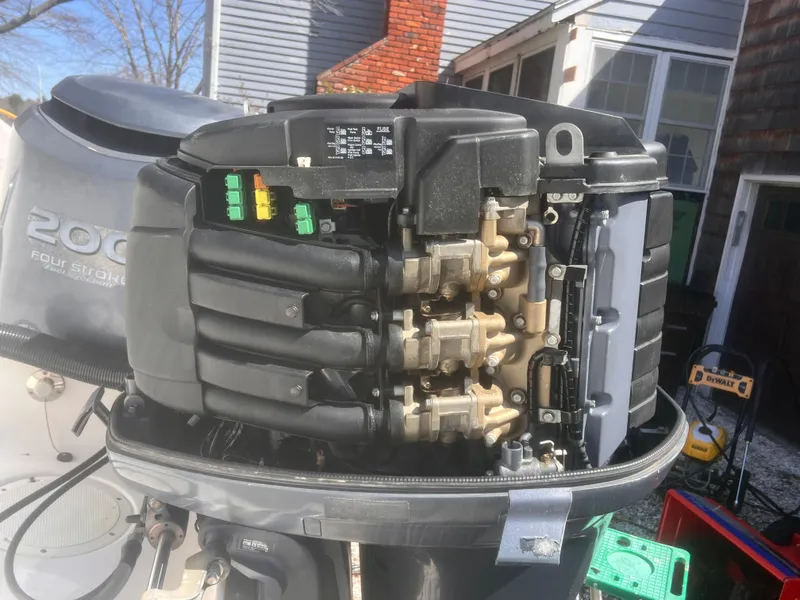 Slide: The Image of 2004 Robalo R225 Walkaround boat engine with exposed components in a residential setting. - 10