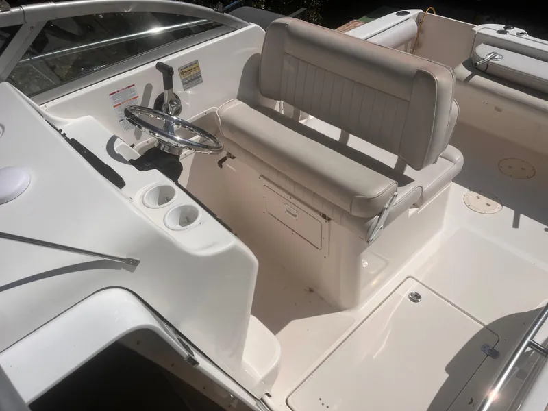 Slide: The Image of 2004 Robalo R225 Walkaround boat interior with steering wheel and seating area. - 16