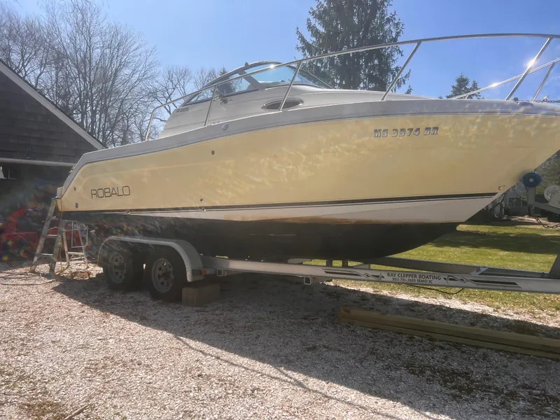 Slide: The Image of 2004 Robalo R225 Walkaround boat on trailer, parked outdoors. - 2