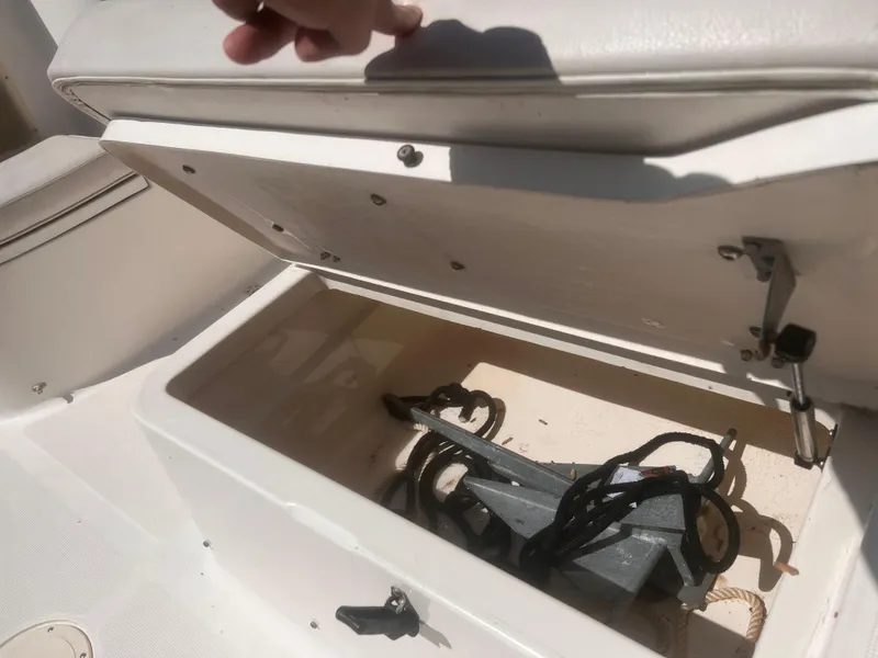 Slide: The Image of Storage compartment on a 2004 Robalo R225 Walkaround boat, containing an anchor and ropes. - 27
