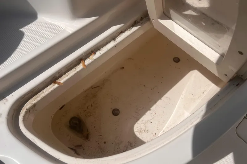 Slide: The Image of 2004 Robalo R225 Walkaround boat storage compartment, showing interior details and drainage. - 39