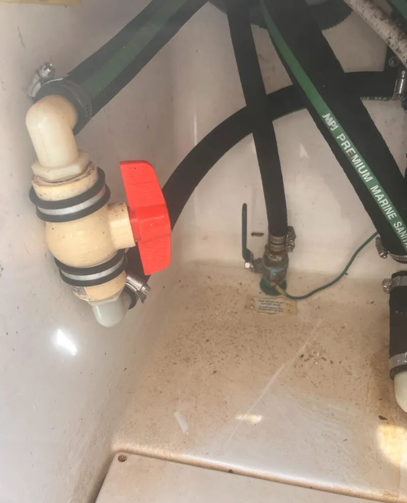 Slide: The Image of 2004 Robalo R225 Walkaround boat plumbing with hoses and valve. - 41