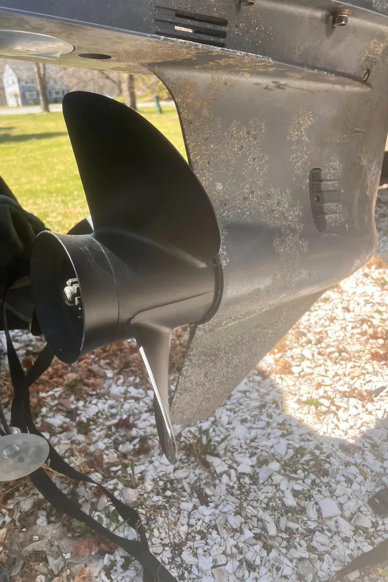 Slide: The Image of 2004 Robalo R225 Walkaround boat propeller on gravel surface. - 44