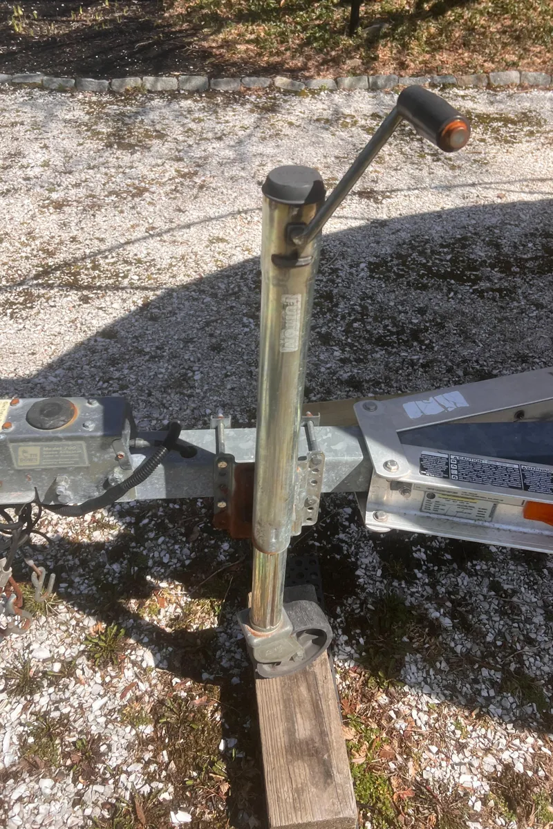 Slide: The Image of Trailer hitch and jack for 2004 Robalo R225 Walkaround boat on gravel surface. - 45