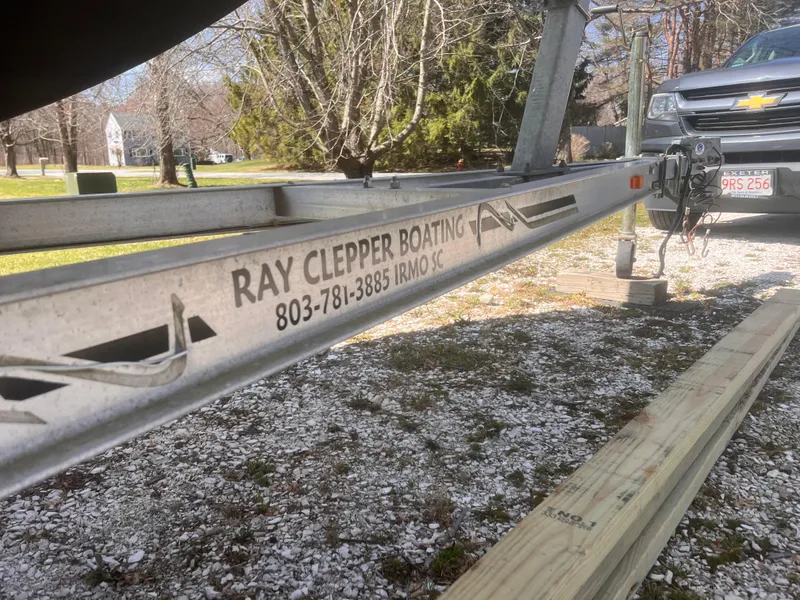 Slide: The Image of 2004 Robalo R225 Walkaround boat trailer by Ray Clepper Boating, parked on gravel. - 46