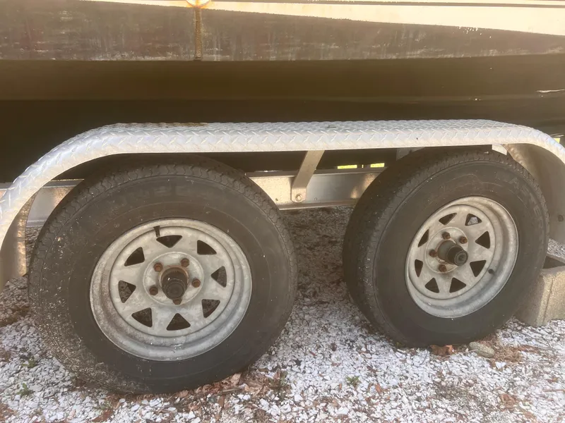 Slide: The Image of Trailer wheels for 2004 Robalo R225 Walkaround boat on gravel surface. - 48