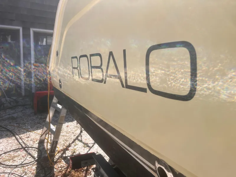 Slide: The Image of 2004 Robalo R225 Walkaround boat side view with logo in sunlight. - 5