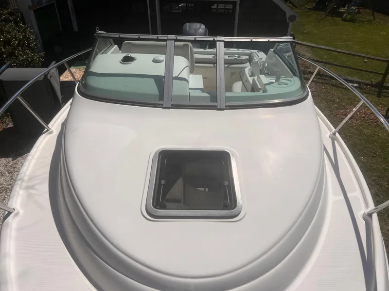 Slide: The Image of 2004 Robalo R225 Walkaround boat with open hatch and sleek design. - 8