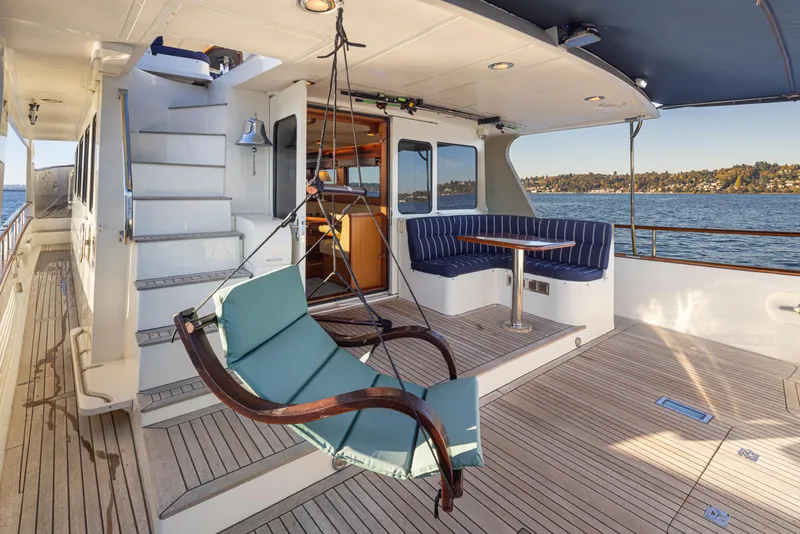 Slide: The Image of Luxury yacht Marlow 72C 2003 with deck seating and hammock, overlooking serene waters. - 10