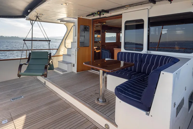 Slide: The Image of Luxurious 2003 Marlow 72C yacht deck with seating, table, and ocean view. - 11