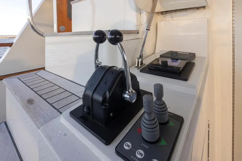 Slide: The Image of Control panel of a 2003 Marlow 72C yacht with throttle levers and joystick controls. - 12