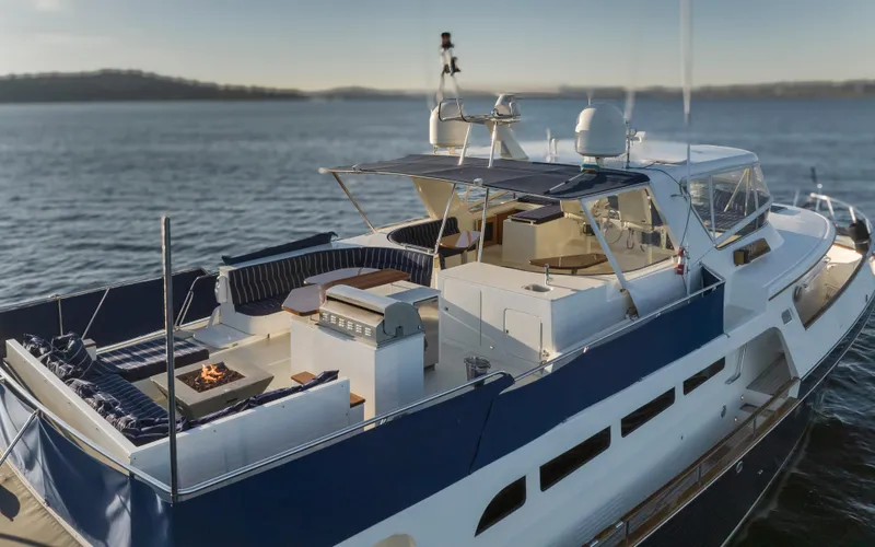 Slide: The Image of Luxurious 2003 Marlow 72C yacht with spacious deck and seating area on calm waters. - 14