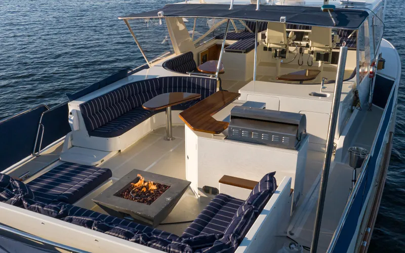 Slide: The Image of Luxurious 2003 Marlow 72C yacht deck with seating, fire pit, and ocean view. - 20